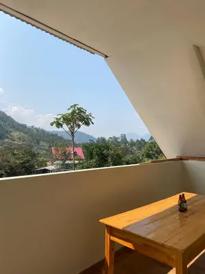 a wooden table in a room with a large window at LagunaNegra Oxapampa in Palmira