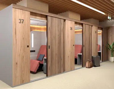 a conference room with sliding glass doors with red chairs at Sleepover - Lima Airport, the only in-terminal sleep pods in Lima