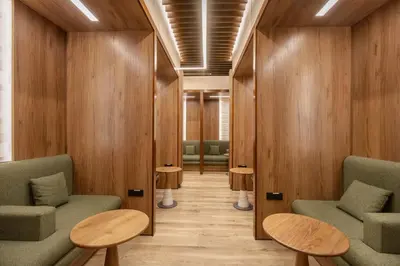 a waiting room with green chairs and wooden walls at Sleepover - Lima Airport, the only in-terminal sleep pods in Lima