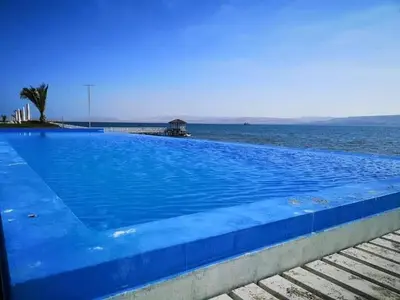 a large blue swimming pool next to the ocean at Condominio Nautico Paracas in Ica