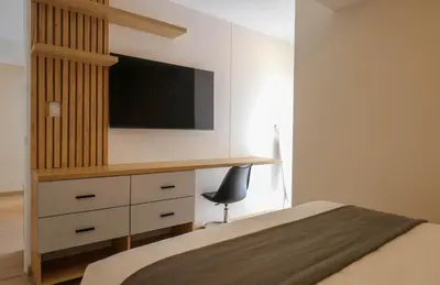 a bedroom with a bed and a desk with a tv at Barron by Wynwood House in Lima