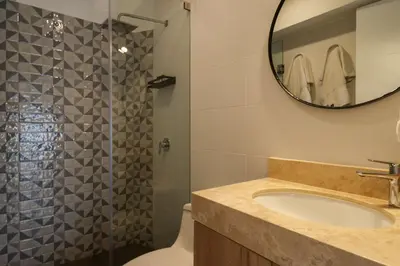 a bathroom with a sink and a shower with a mirror at Barron by Wynwood House in Lima