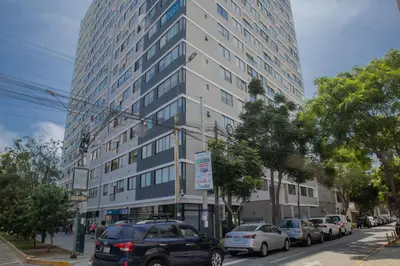 a tall building on a city street with parked cars at Barron by Wynwood House in Lima