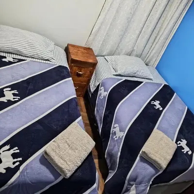two beds in a room with blue and white comforters at Hospedaje Rochi House - Cusco- En el Corazón del Cusco in Cusco