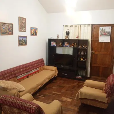 a living room with two couches and a flat screen tv at Hospedaje Rochi House - Cusco- En el Corazón del Cusco in Cusco