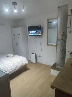 a bedroom with a bed and a tv on the wall at Cómodo Estudio Miraflores in Lima