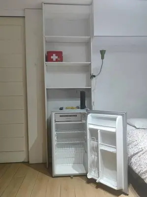 a small white refrigerator in a room with a bed at Cómodo Estudio Miraflores in Lima