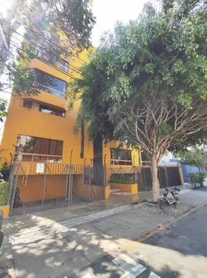 a yellow building with a tree in front of it at Cómodo Estudio Miraflores in Lima