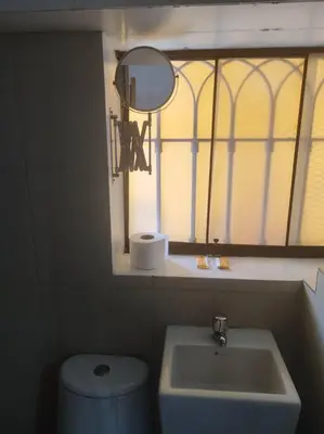a bathroom with a sink and a toilet and a mirror at Cómodo Estudio Miraflores in Lima