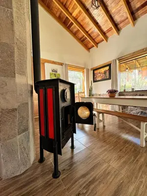 a living room with a stove and a table at casa de campo con jaccuzi in Huaran