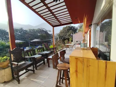 a patio with chairs and a bar with a view at Casa Campo Isabel Quinteros in Chaclacayo