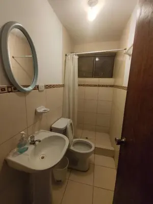 a bathroom with a sink and a toilet and a mirror at Casa Campo Isabel Quinteros in Chaclacayo