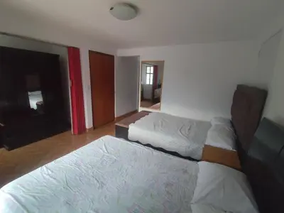 a bedroom with two beds and a mirror at Casa Campo Isabel Quinteros in Chaclacayo