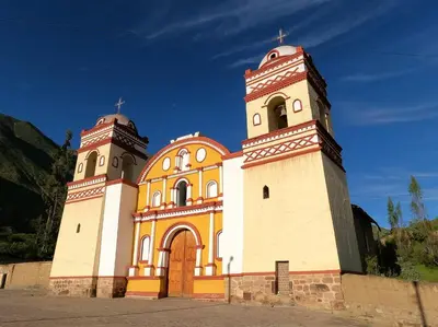 an orange and white church with two towers at HOTEL HUAYTARA CasaBlanca in Huaytará