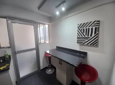 a room with a desk and a red stool and a painting at Depa El Polo, Embajada USA, Surco in Lima