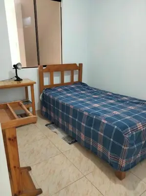 a bedroom with a bed and a wooden table at Departamento Pisco - San Andrés, cerca a Paracas in Gallinazos Hacienda
