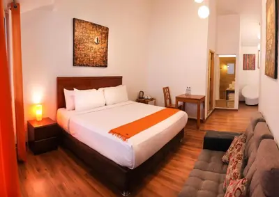 a bedroom with a large bed and a bathroom at Suites Machupicchu in Machu Picchu
