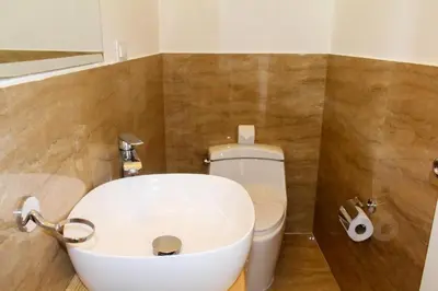 a bathroom with a white toilet and a sink at Suites Machupicchu in Machu Picchu