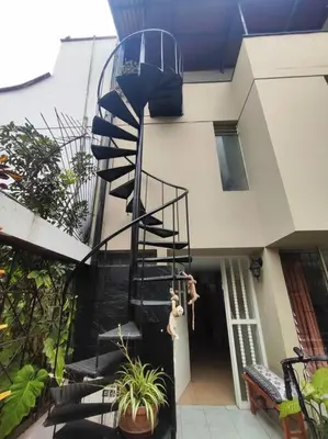 a spiral staircase leading into a building with plants at Cómoda habitación independiente in Lima