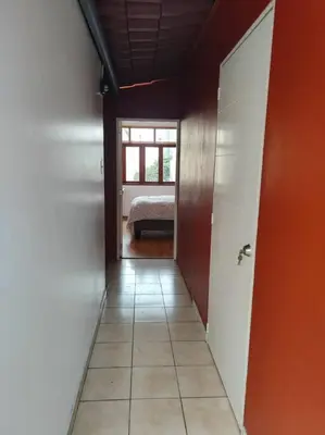 a hallway with a room with a bed and a window at Cómoda habitación independiente in Lima