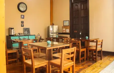 a restaurant with tables and chairs and a clock on the wall at Villa La Punta in Lima