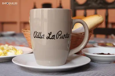 a coffee cup on a table with plates of food at Villa La Punta in Lima