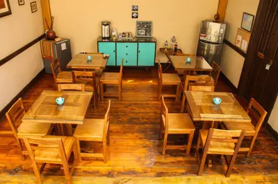 an empty restaurant with wooden tables and chairs at Villa La Punta in Lima
