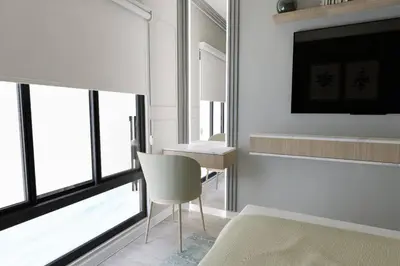 a bedroom with a bed and a table and a chair at Departamento Vista al Mar Cerca Aeropuerto y Miraflores in Lima