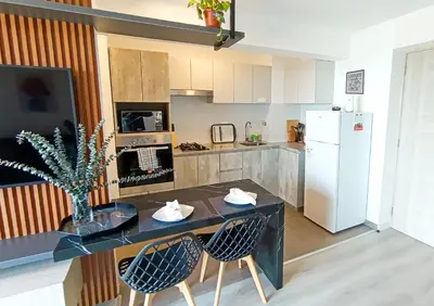 a kitchen with a table and two chairs and a refrigerator at Departamento Vista al Mar Cerca Aeropuerto y Miraflores in Lima