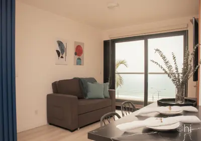 a living room with a couch and a table at Departamento Vista al Mar Cerca Aeropuerto y Miraflores in Lima