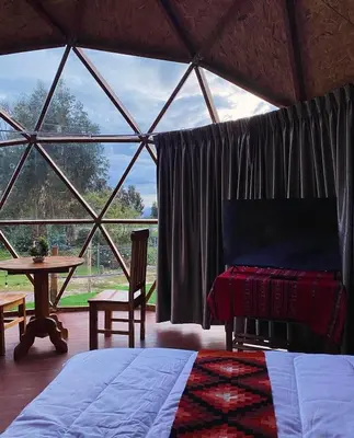 a room with a bed and a table and a window at Antawara Glamping in Chipingura