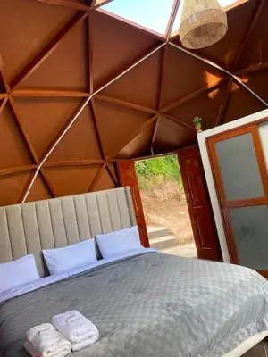 a bedroom with a large bed with two towels on it at Antawara Glamping in Chipingura