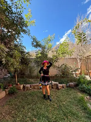 a woman standing in the grass with a mountain in the background at Tambo Real Valle Sagrado in Yucay