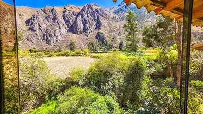 a view of a mountain range from a house at PERU QUECHUA'S LODGE Riverside in Ollantaytambo