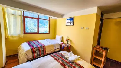 a bedroom with two beds and a window at PERU QUECHUA'S LODGE Riverside in Ollantaytambo