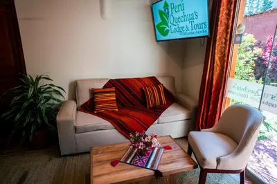 a living room with a couch and a coffee table at PERU QUECHUA'S LODGE Riverside in Ollantaytambo