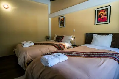 a hotel room with two beds with towels on them at PERU QUECHUA'S LODGE Riverside in Ollantaytambo