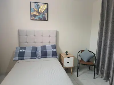 a bedroom with a bed and a chair at departamento airport in Lima