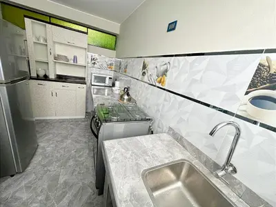 a small kitchen with a sink and a refrigerator at departamento airport in Lima