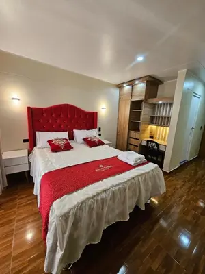 a bedroom with a large bed with a red headboard at Hotel Sumac Samari in Puquio