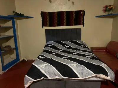 a bed in a room with a blanket on it at Habitación con recojo desde el aereopuerto in Cusco