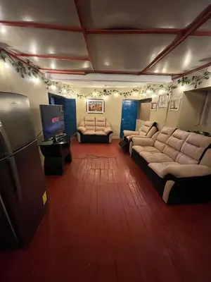 a living room with couches and a flat screen tv at Habitación con recojo desde el aereopuerto in Cusco