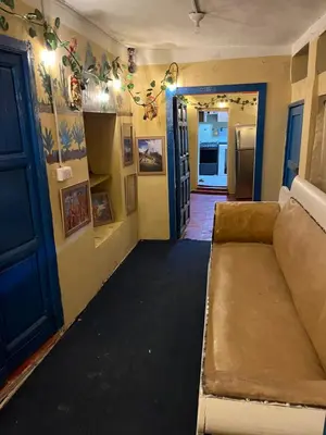 a living room with a couch and a blue door at Habitación con recojo desde el aereopuerto in Cusco