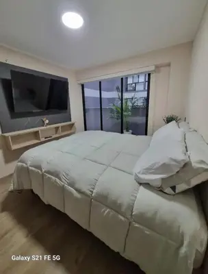 a large bedroom with a large bed and a television at María Paz Home in Lima