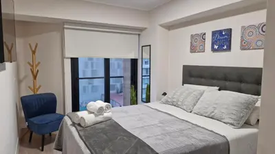 a bedroom with a large bed and a blue chair at Departamento en Barranco - Like at Home in Lima