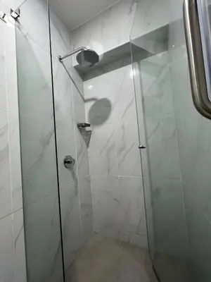 a shower with a glass door in a bathroom at Av arequipa 603B in Lima