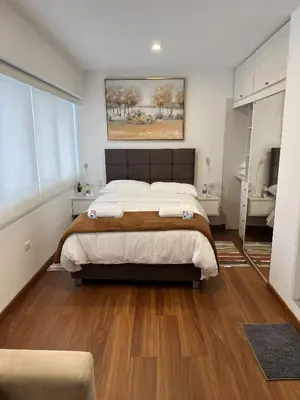 a bedroom with a large bed and wooden floors at Av arequipa 603B in Lima