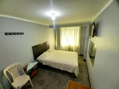 a bedroom with a bed and a chair and a window at Francisco D Francisco in Lima