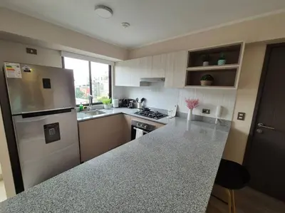 a kitchen with a refrigerator and a counter top at Moderno departamento San Isidro in Lima