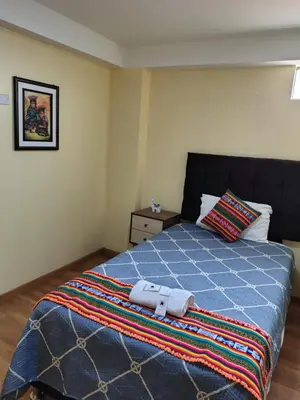 a bedroom with a blue bed with a towel on it at Departamento en La casa de Teresita in Cusco